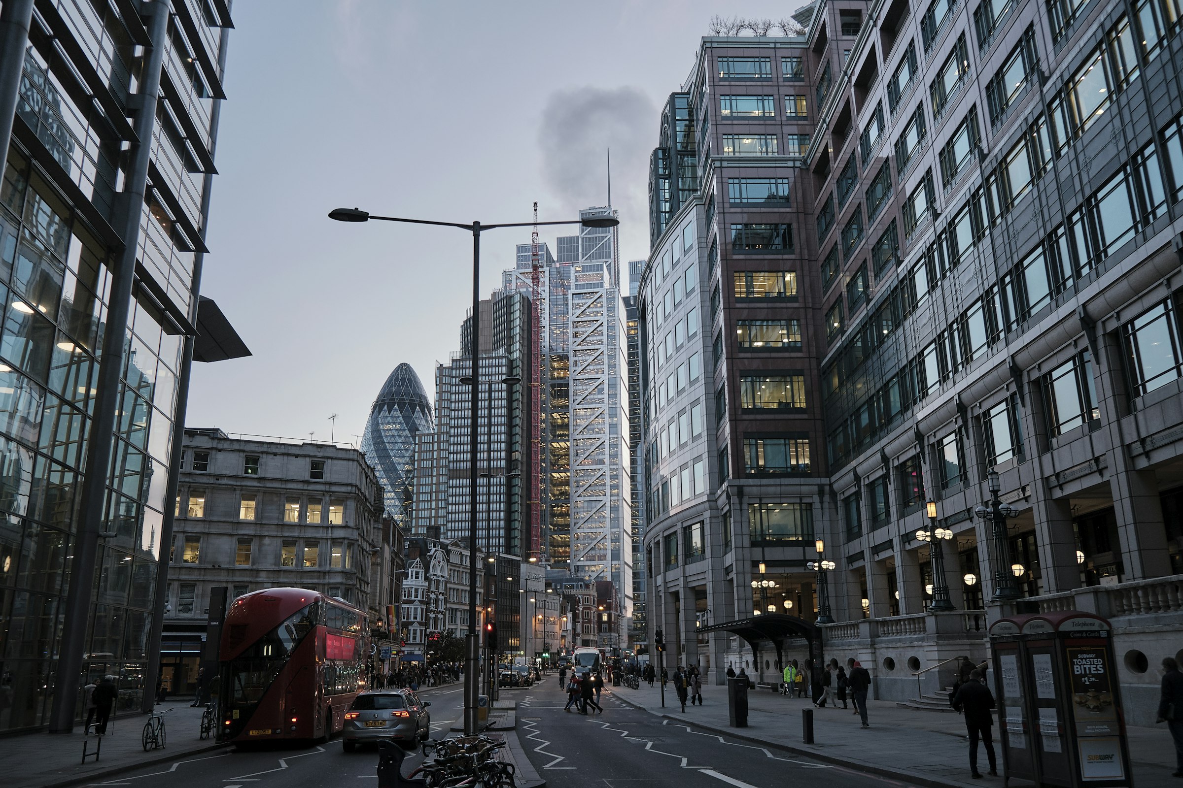 A London business-district street with a red double-decker bus